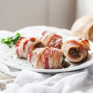 Close up of bacon wrapped chicken thighs on a plate