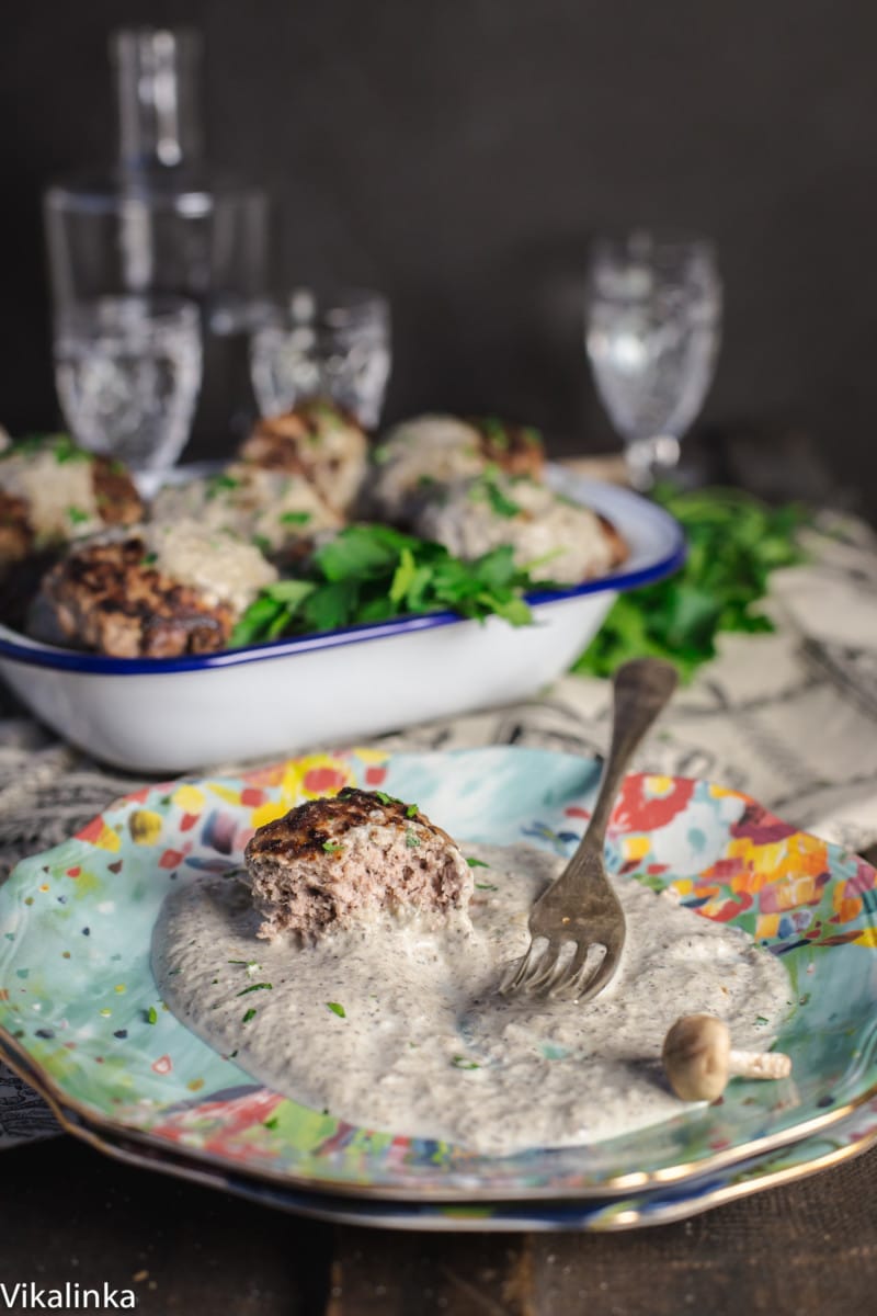 beef patty with creamy sauce on a blue plate