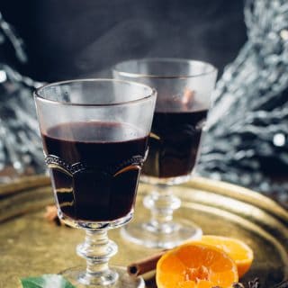 mulled wine in glasses on tray with orange halves