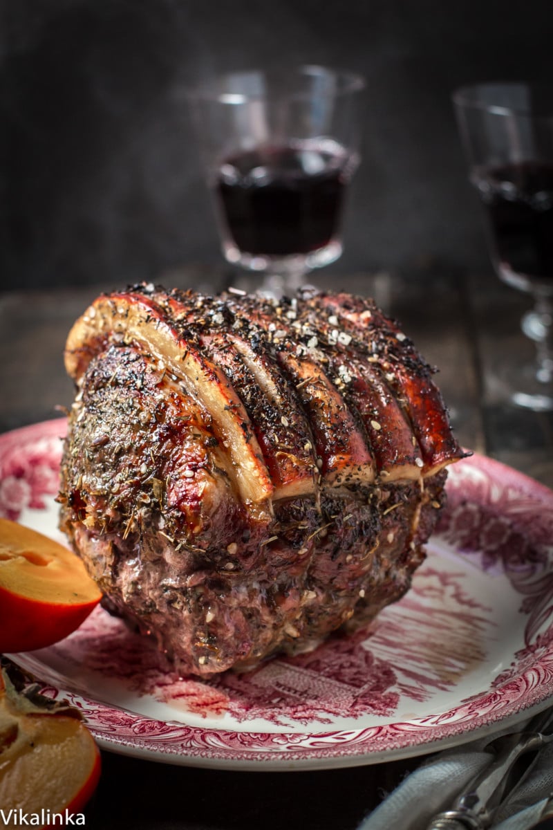 Cooked roast on a serving platter with an opened persimmon