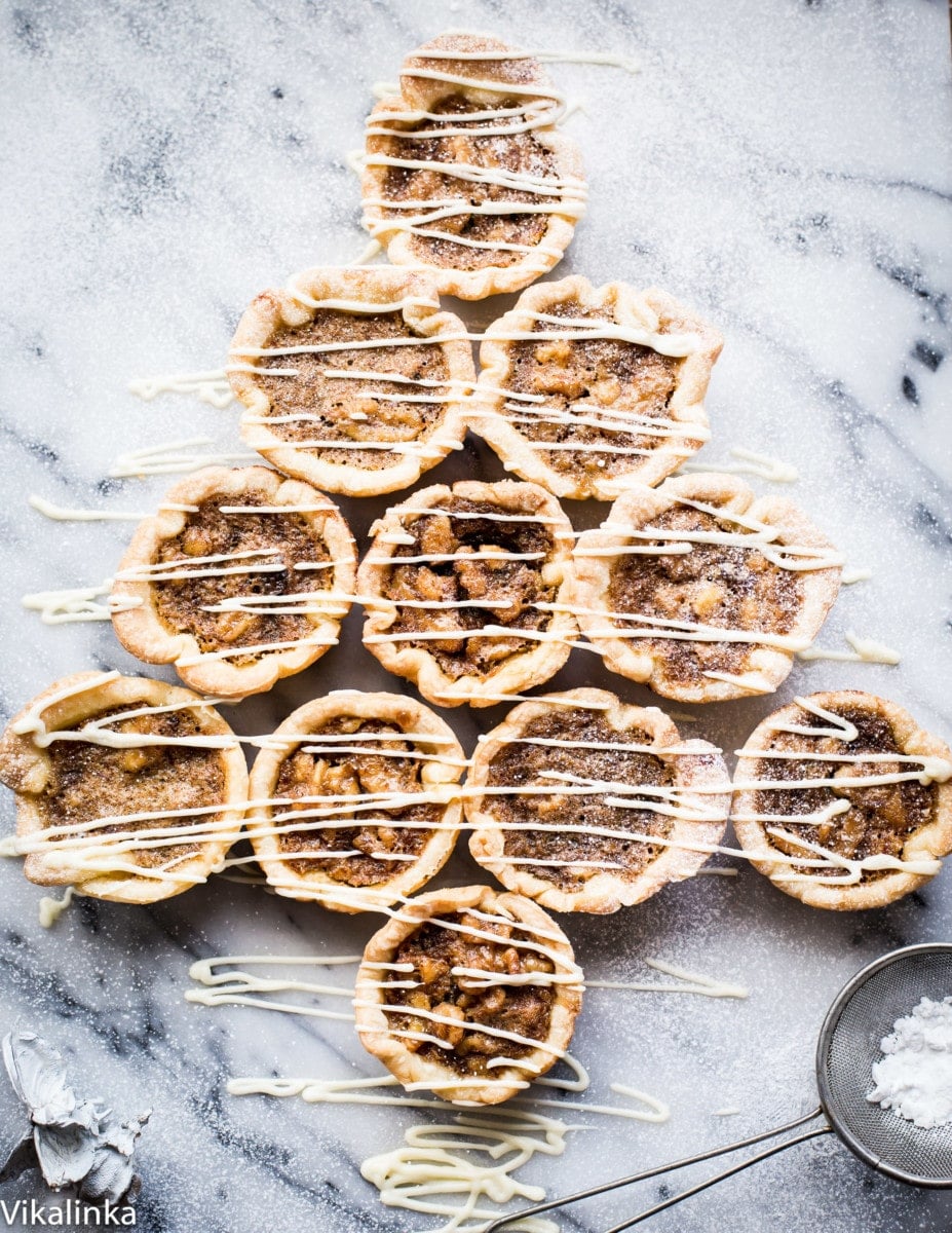 Butter Tarts-flaky pastry tartlets filled with delicious golden custard, raisins and walnuts.