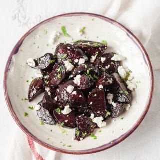 Top down view of beets with goats cheese and mint on a plate
