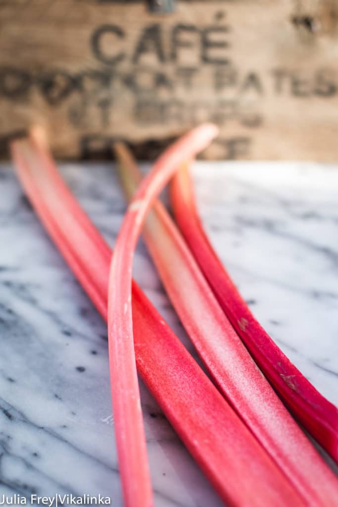 Four stalks of rhubarb on a marble table