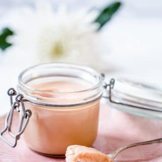 Rhubarb curd in a glass container with a spoon