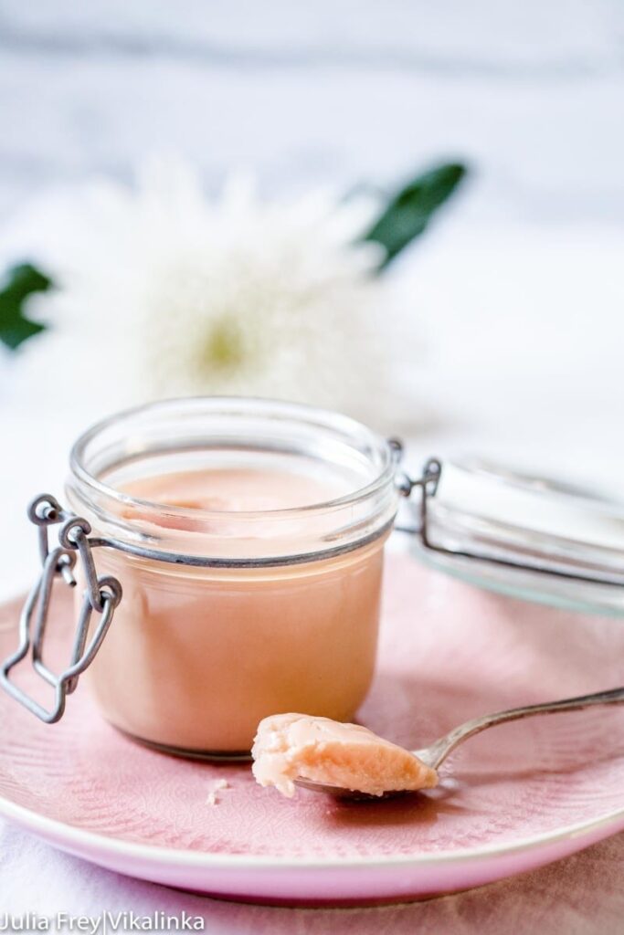 Rhubarb curd in a glass container with a spoon