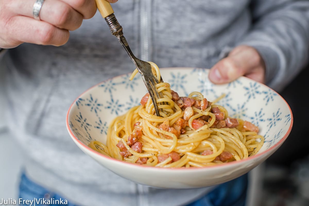 Hand holding pasta bowl