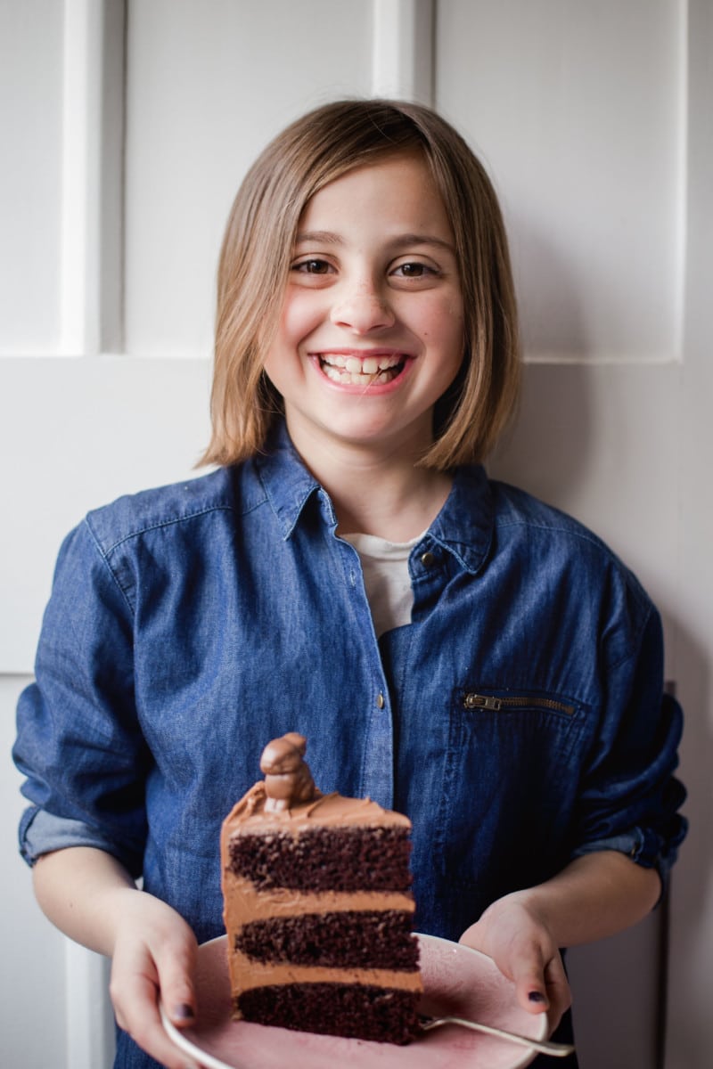 side shot of girl holding slice of cake