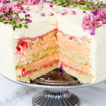 layer cake with a slice cut our exposing vanilla sponge and rhubarb curd filling