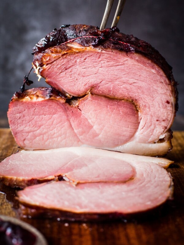 cooked ham with a piece cut and lying in front