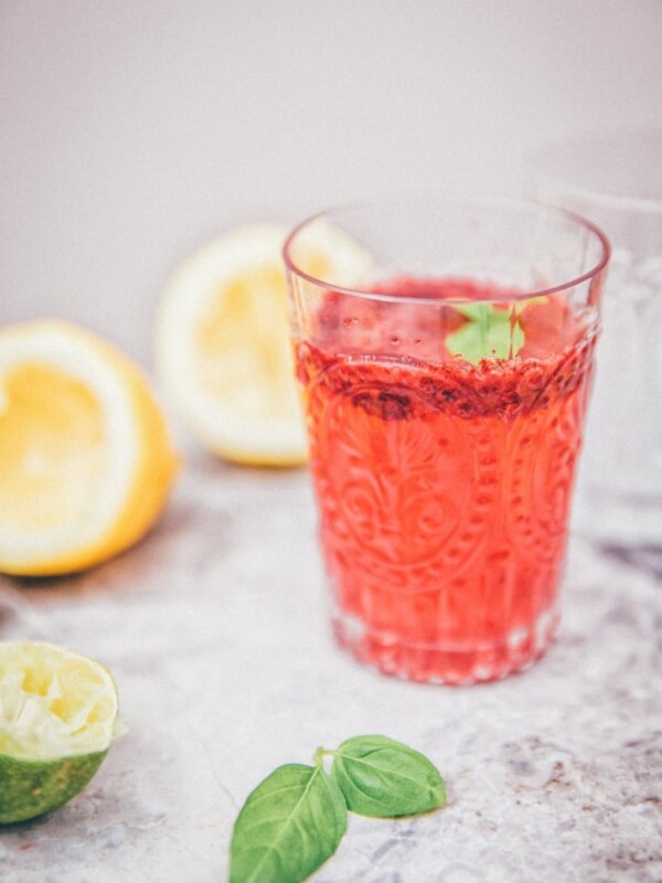 Side view of blackberry basil lemonade in a clear glasss