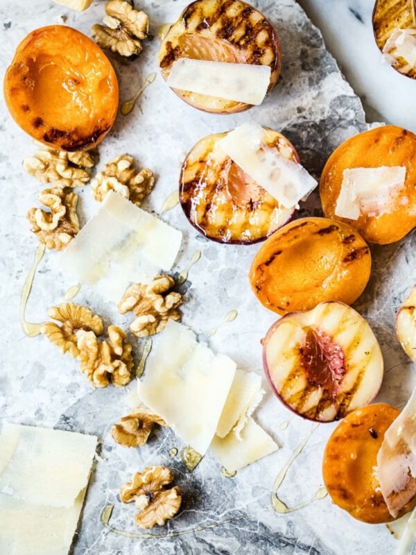 Top down view of grilled fruit with cheese and walnuts on marble slab