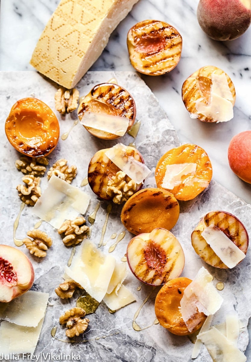 Apricots and peaches showing grill marks and other ingredients on marble