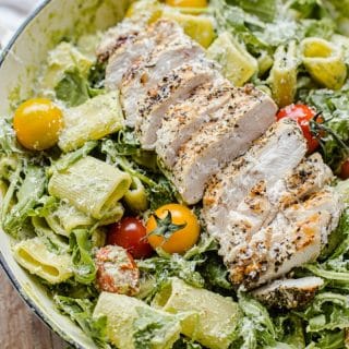 Pesto Pasta with sliced grilled chicken, cherry tomatoes and arugula.