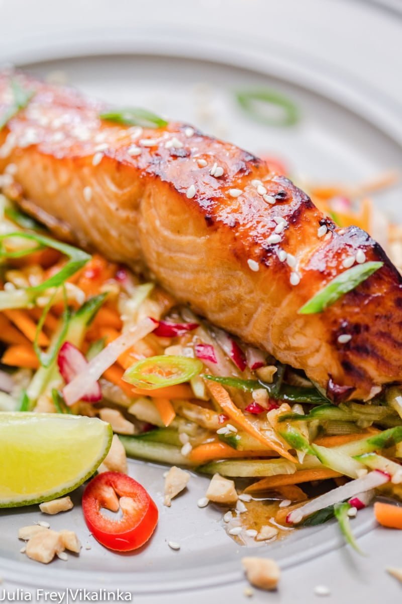 Asian glazed salmon on top of carrot and cucumber slaw with chillies. 