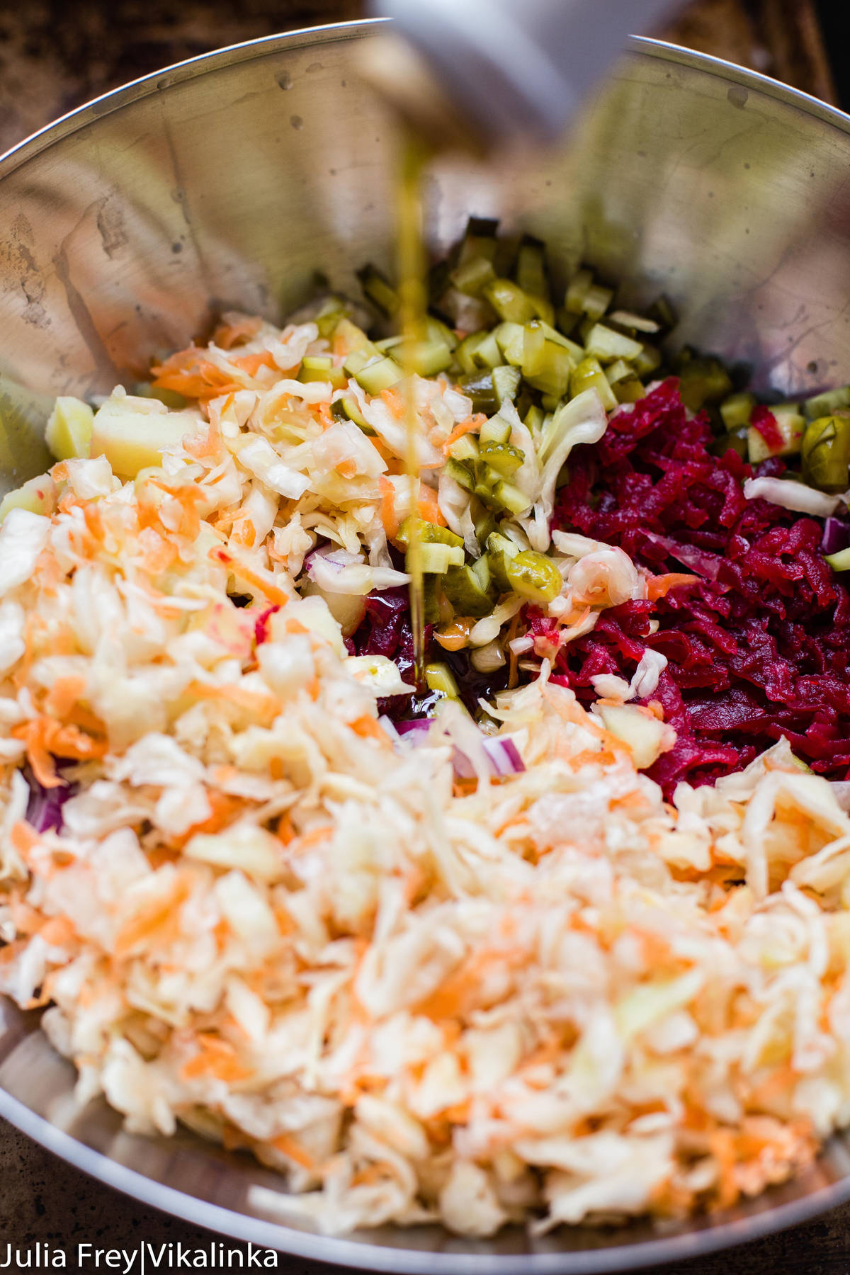 sauerkraut, grated beets and pickles in a stainless steel bowl