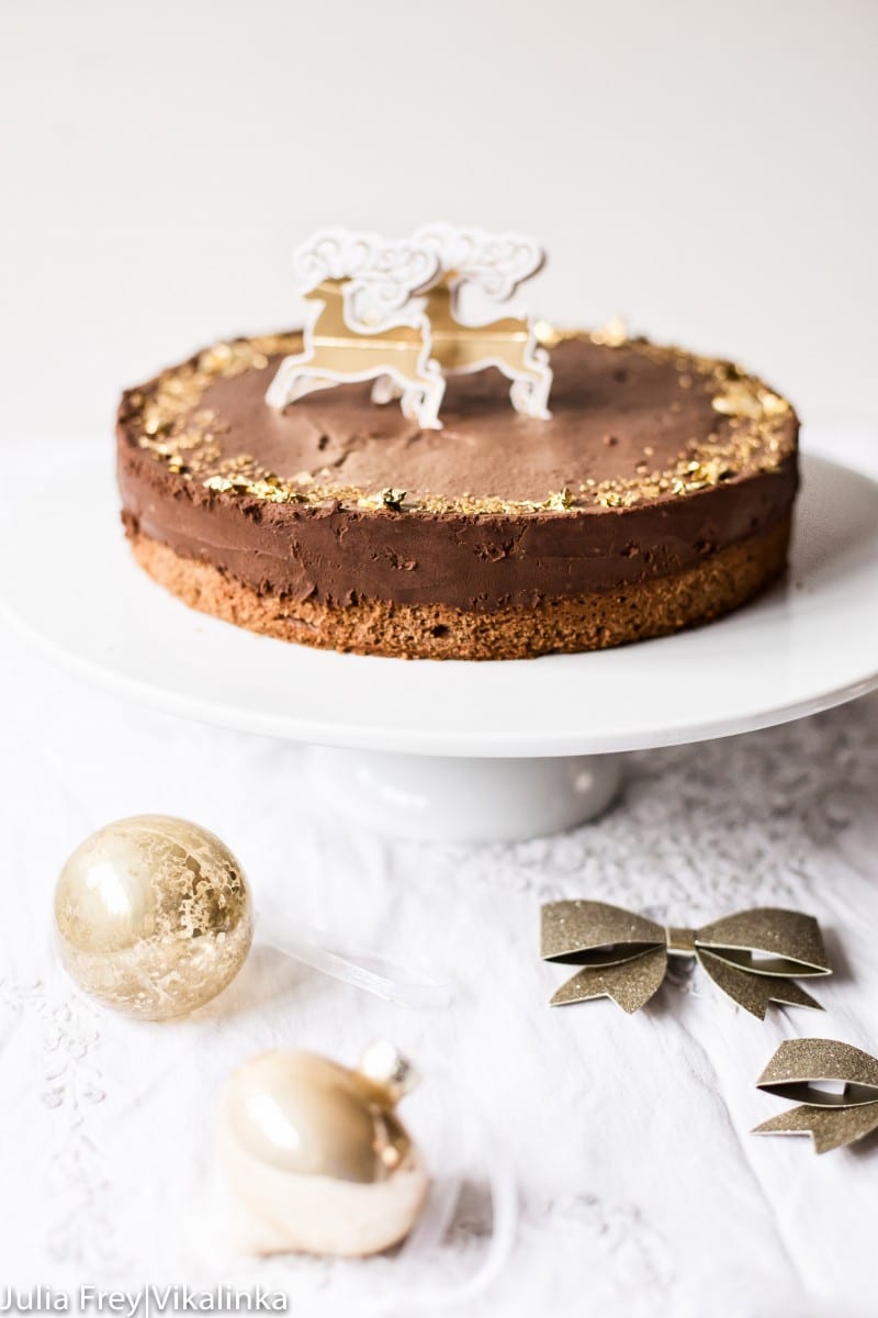 chocolate truffle cake decorated with edible gold leaf on white cake stand