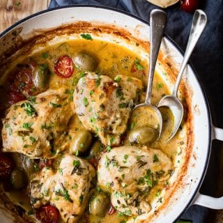top down view of chicken breasts with olives, tomatoes in a pan sauce