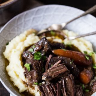 Bowl with the stew on mashed potatoes with cutlery