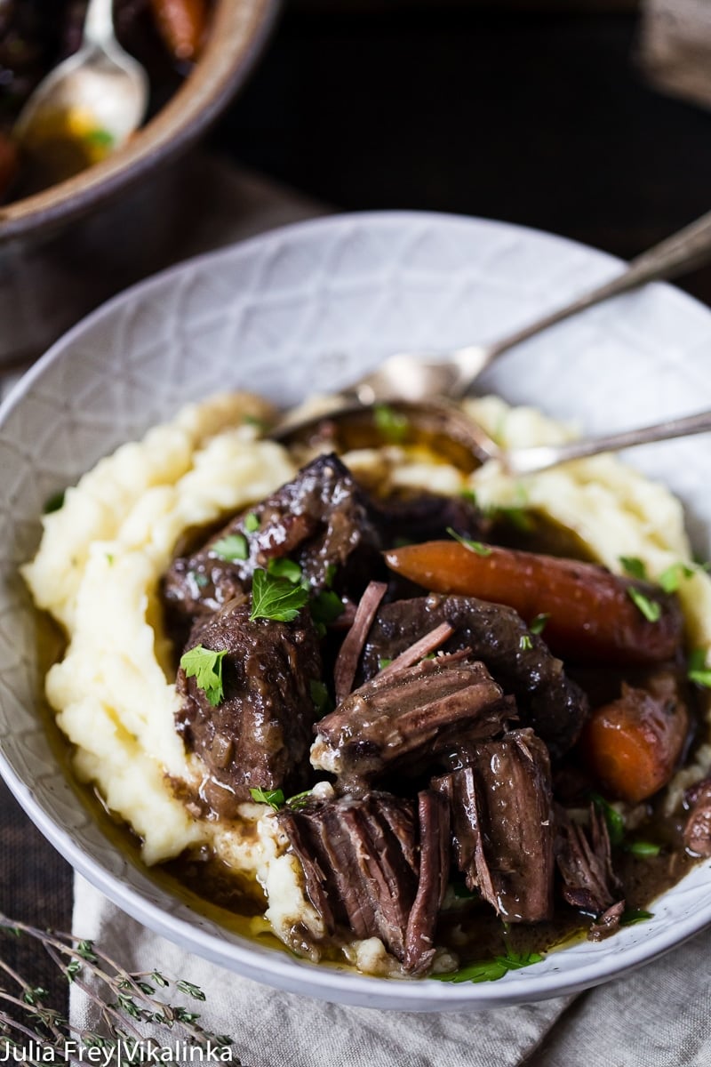 Bowl with the stew on mashed potatoes with cutlery