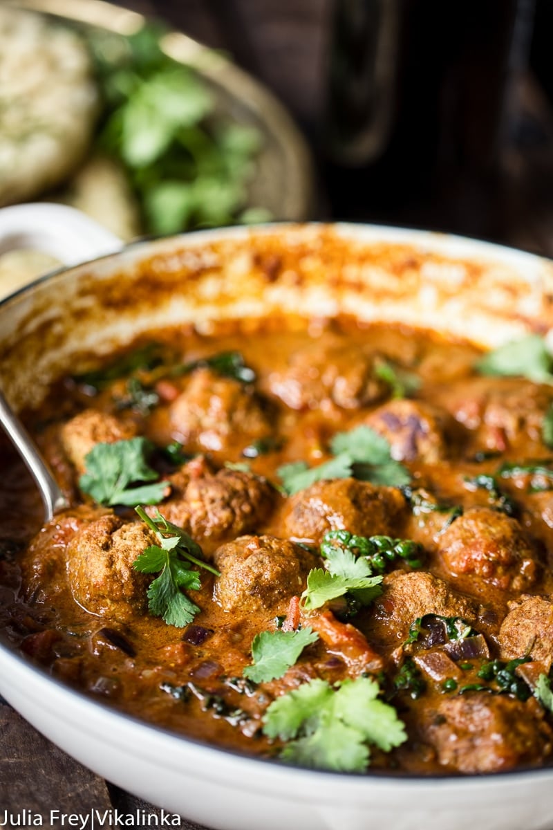 meatball curry topped with fresh cilantro in a white enamel pan