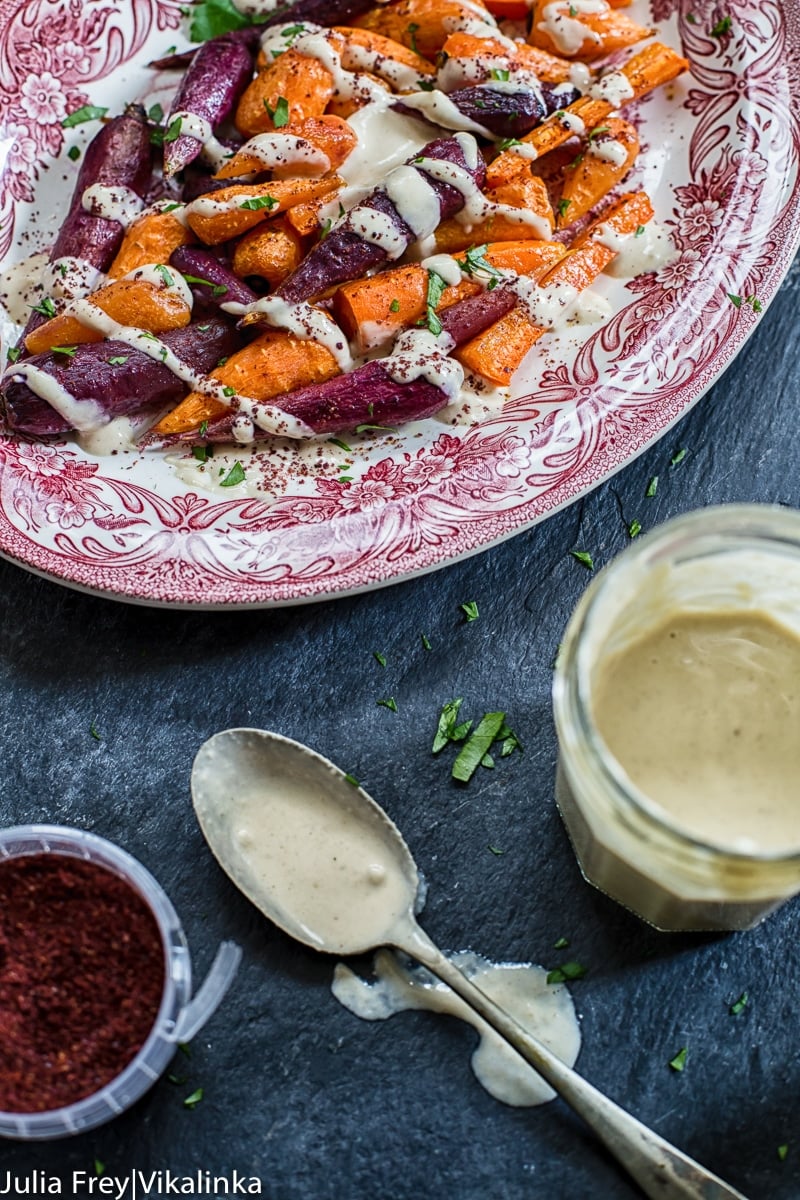 platter of roasted carrots with jam jar of garlicky tahini sauce