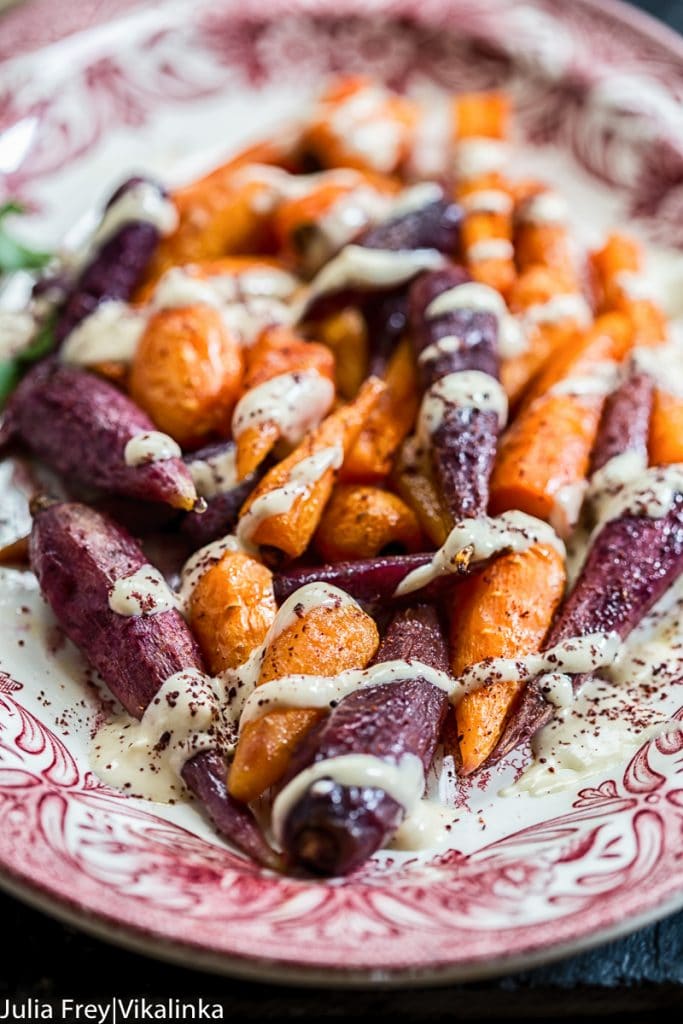 plate of roasted carrots with drizzled tahini sauce