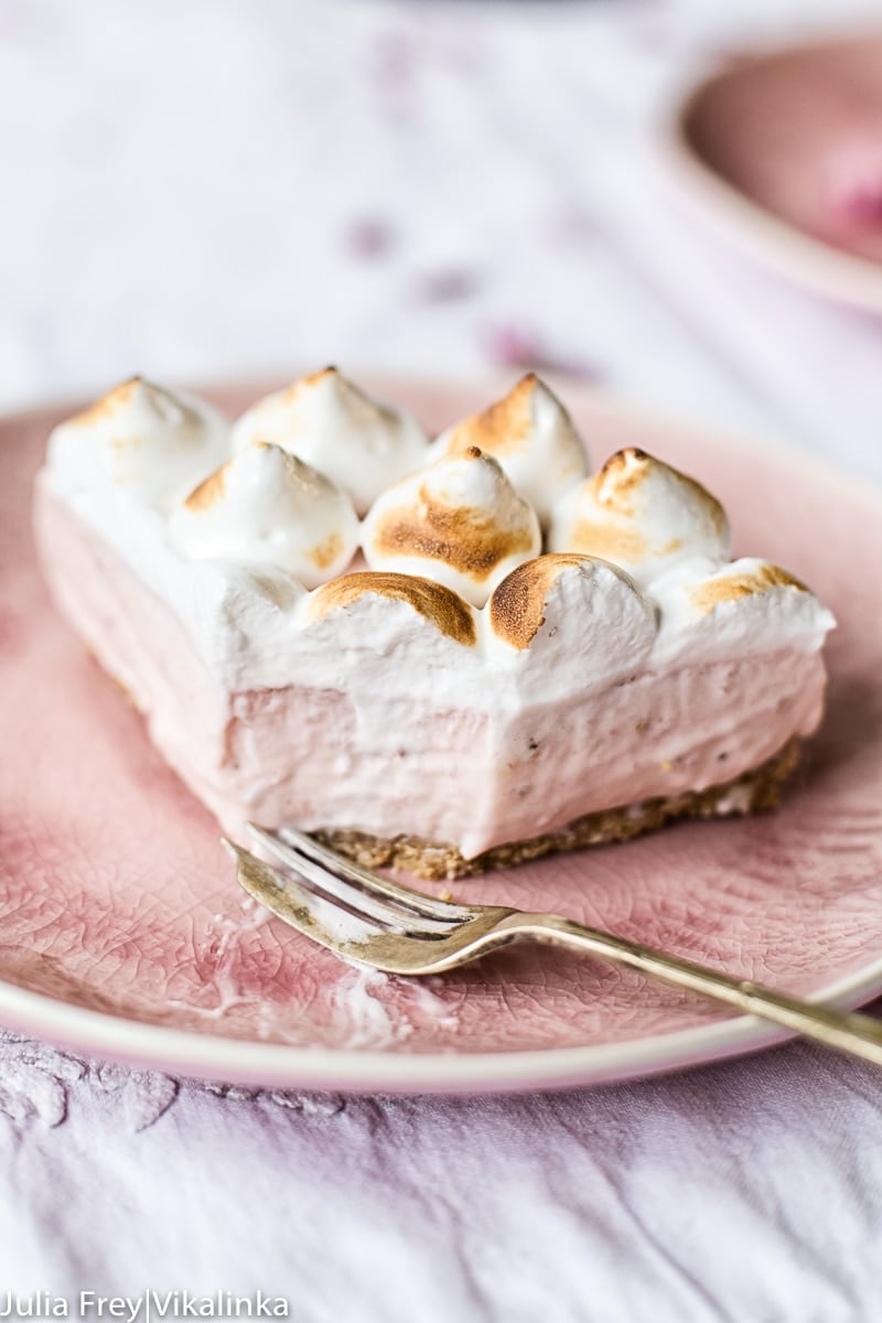 Piece of cheesecake with one piece removed by fork