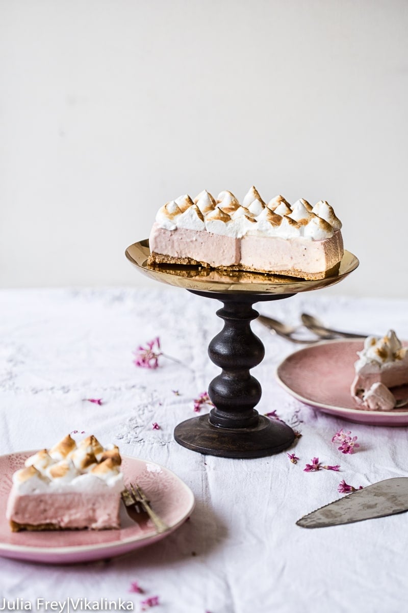 Cheesecake on a cake stand with pieces removed and plated