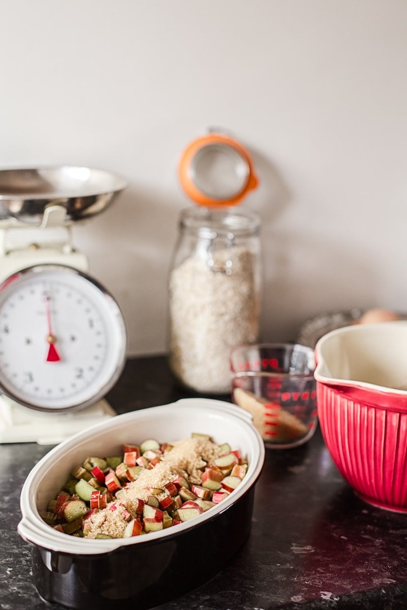 the raw ingredients on a kitchen counter with baking dishes and scale