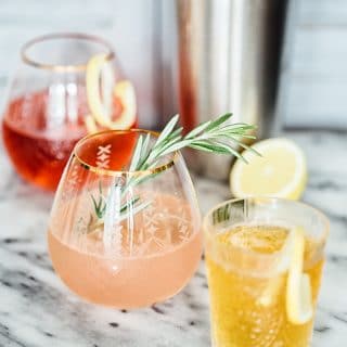 Side shot of red, pink and orange coloured gin and tonic drinks in glasses