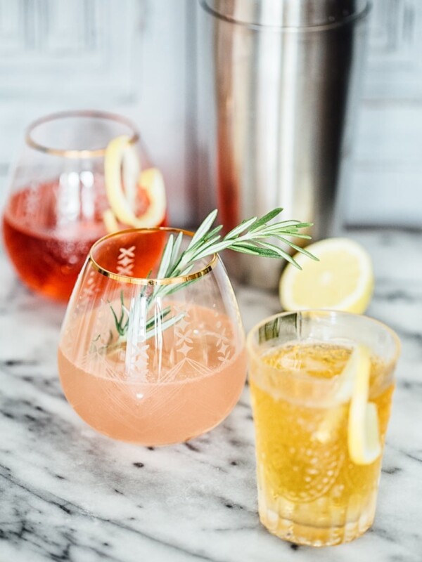 Side shot of red, pink and orange coloured gin and tonic drinks in glasses