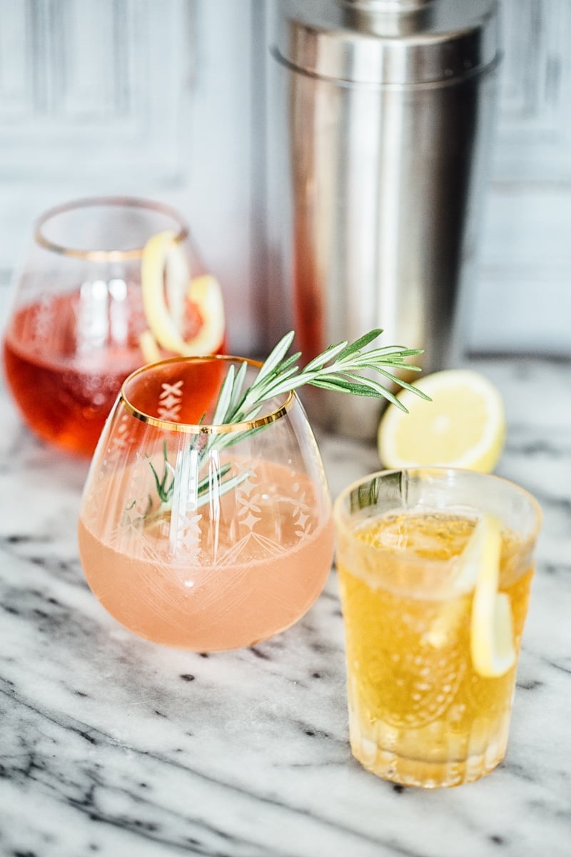 Side shot of red, pink and orange coloured gin and tonic drinks in glasses