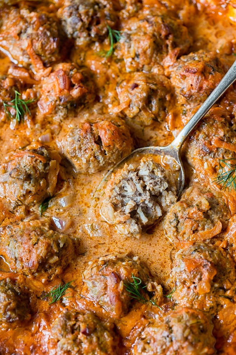 close up of porcupine meatballs with one meatball on a spoon