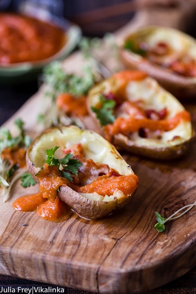 Close up of loaded potatoes showing bravas sauce dripping down