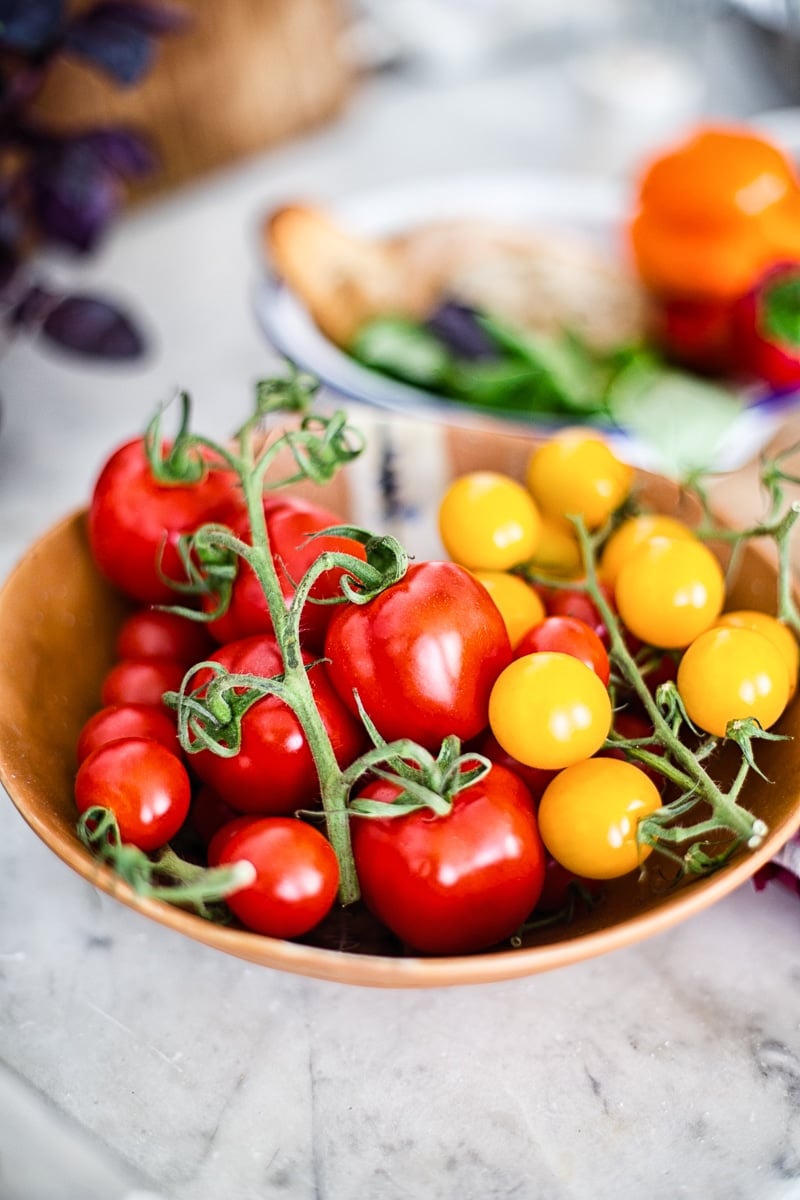 red and yellow tomatoes in brown bowl