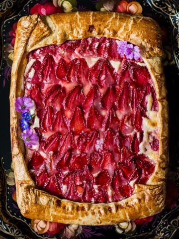 View of strawberry galette with pink flowers as decoration