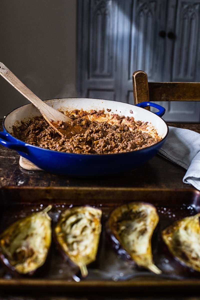 Hollowed out eggplants in front of pan with stuffing