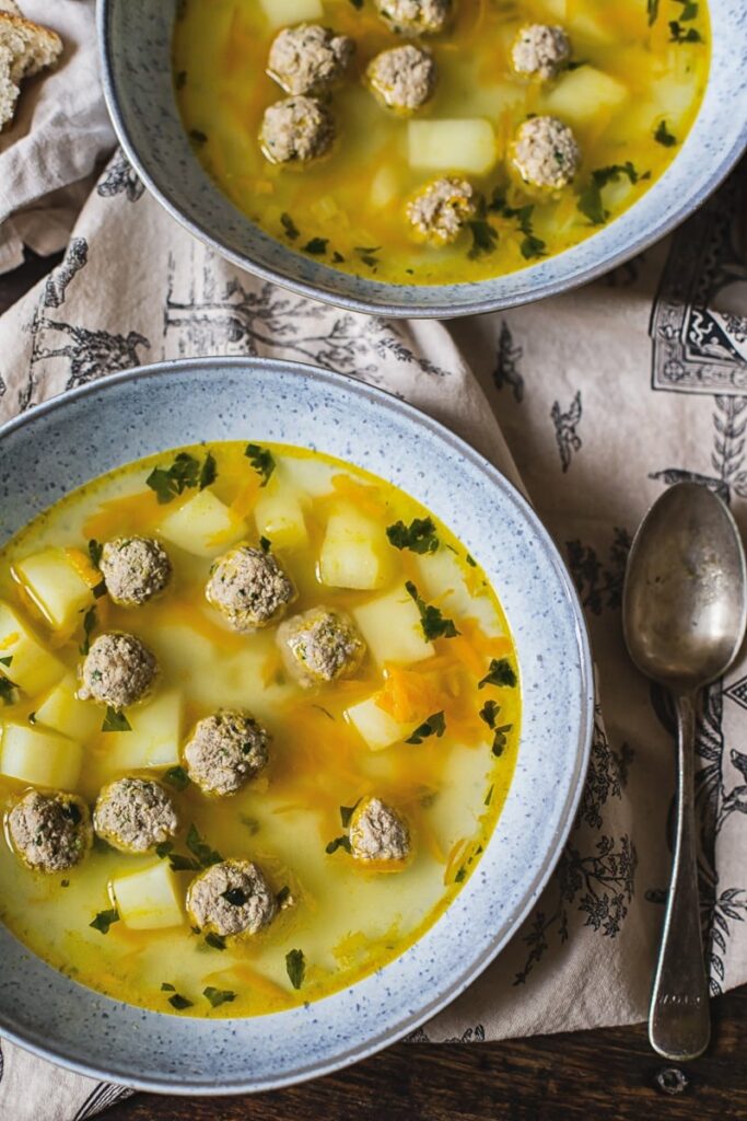 Two bowls of Russian Soup on a table seen from top down