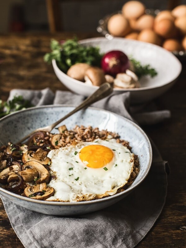Buckwheat breakfast bowl with a fried egg in front of raw ingredients
