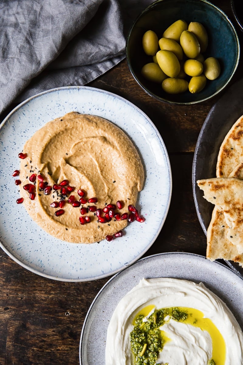 Top down of a table spread with range of items including flatbread and olives