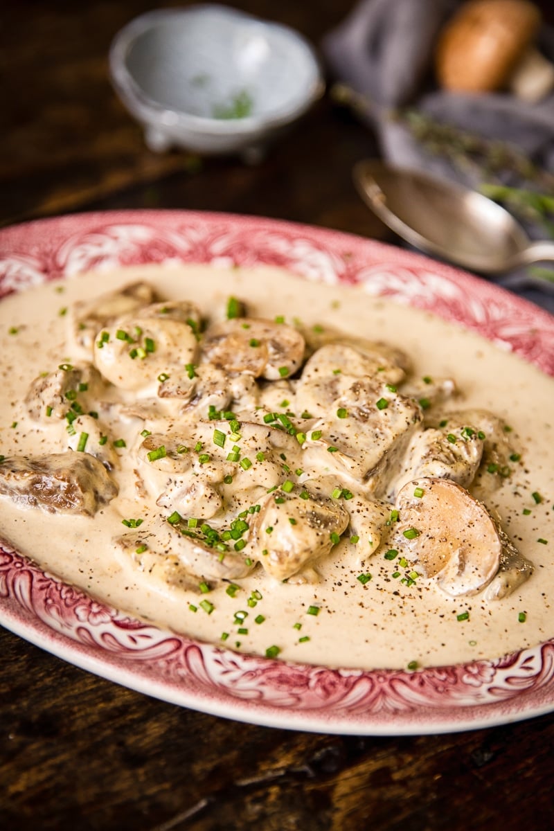 Plate of crimson meat in truffled cream sauce with herbs