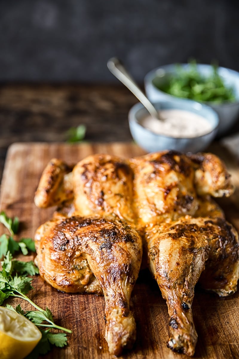 Spatchcocked Chicken in Spicy Yogurt Sauce on a wooden board