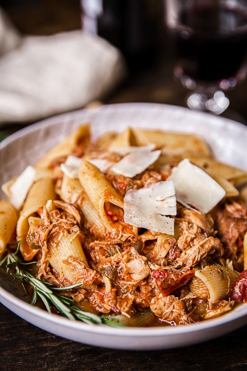 Bowl of chicken ragu pasta with large cheese shavings