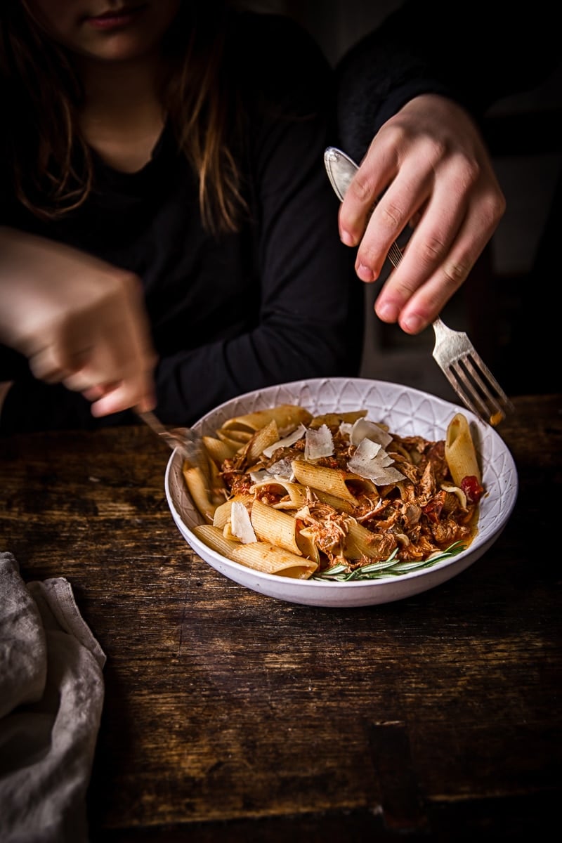 Hands reaching for portions of the dish with forks