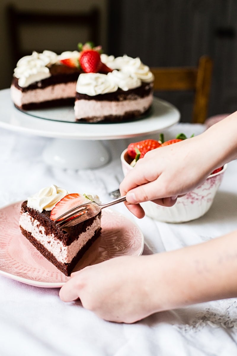 Hand with fork taking piece of cake