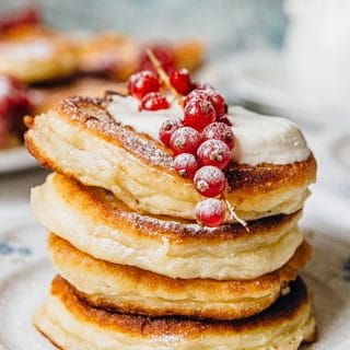 Stack of four pancakes on a plate with berries