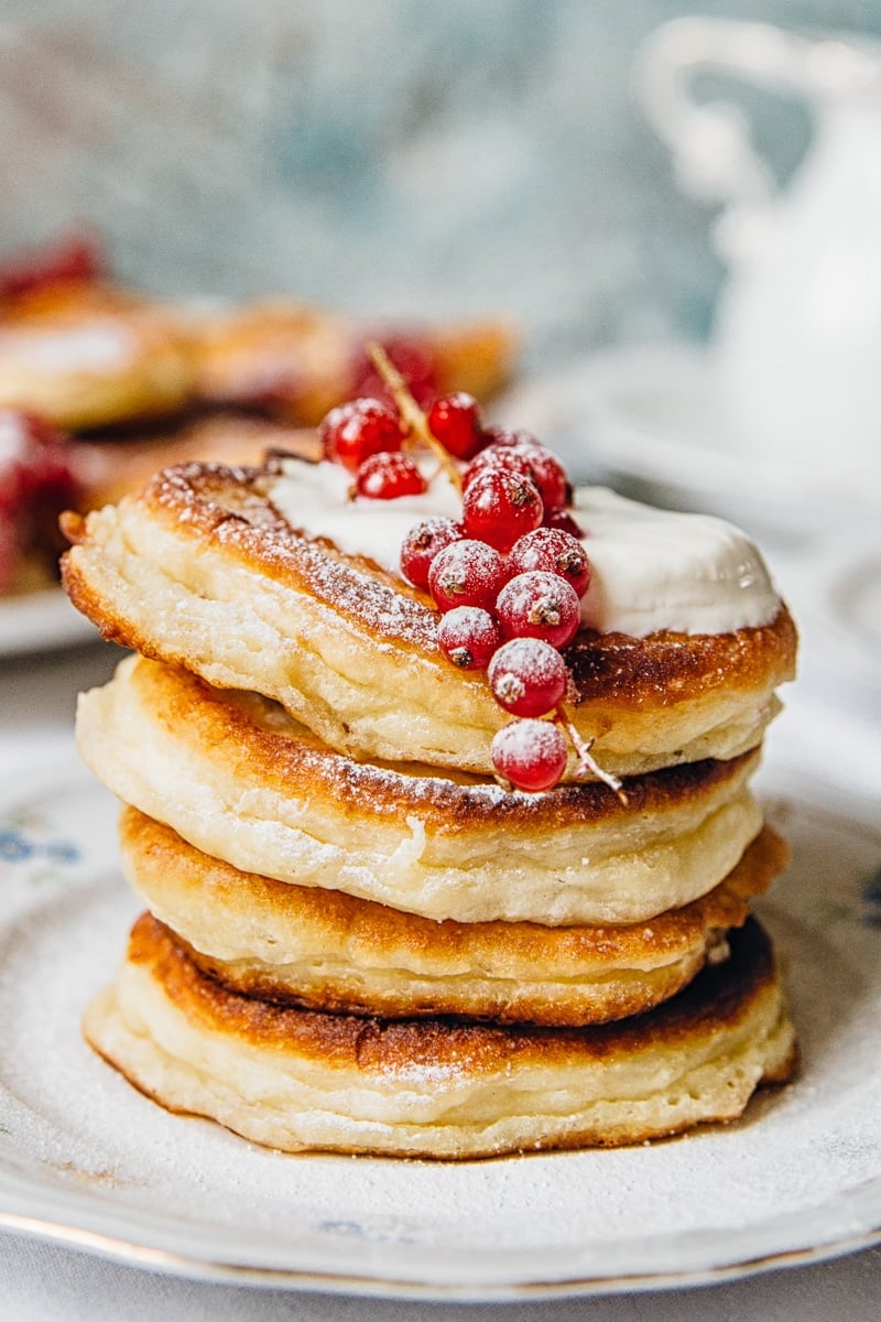 Stack of four pancakes on a plate with berries