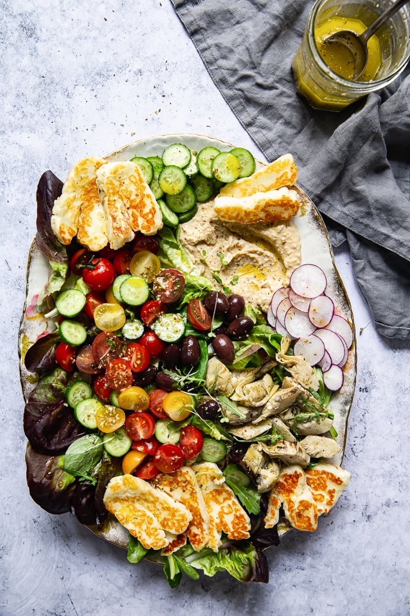 Top down view of Mediterranean Salad with Hummus and Fried Halloumi salad on a platter