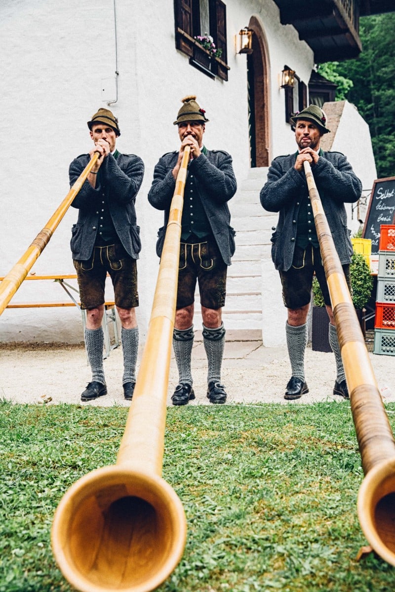 Three alphorn players in lederhosen at Lederhosendonnerstag