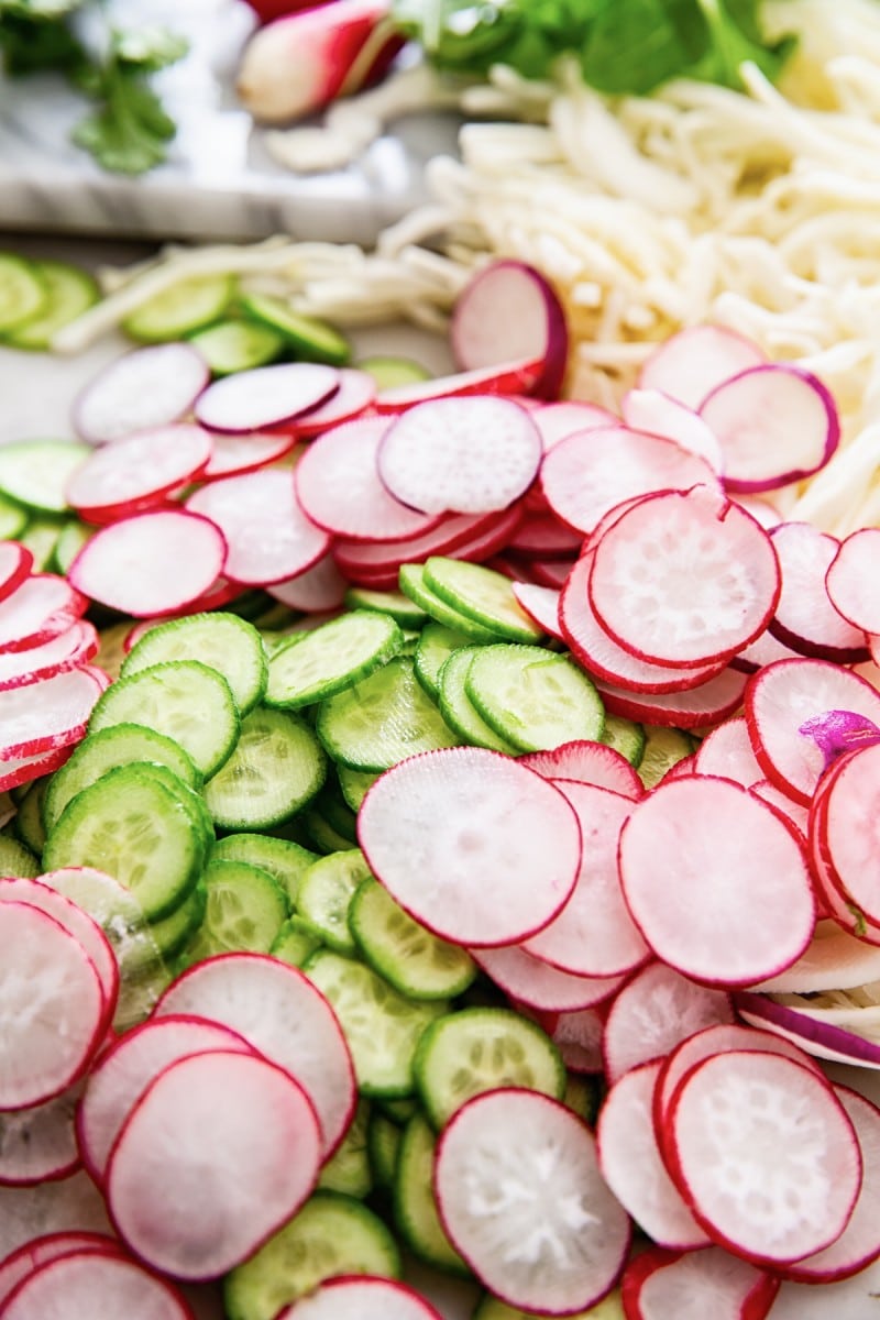Close up of sliced cucumbers and radishes